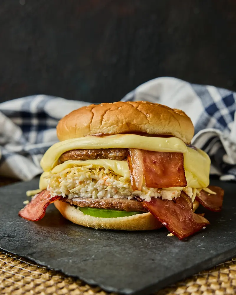 Hamburguesa con tocineta y queso fundido sobre tabla de pizarra