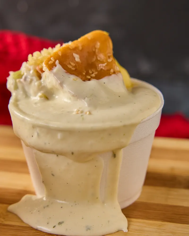 Vaso de papas bañadas en queso mozzarella fundido