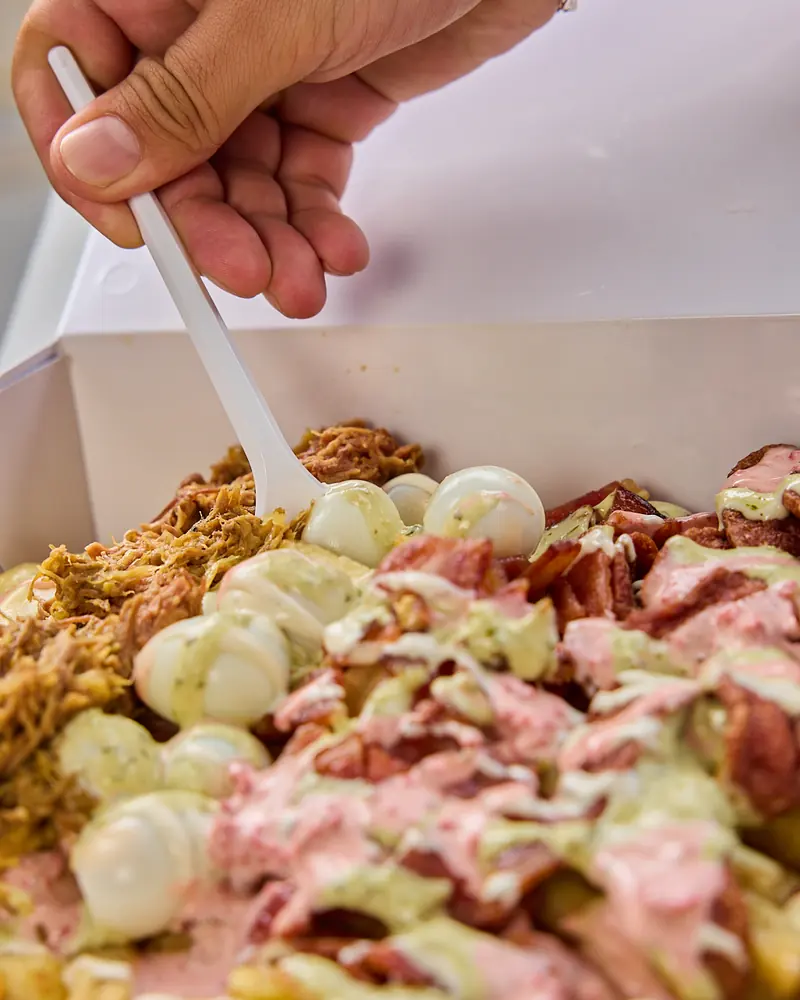Salchipapas con las tres salsas de la casa servidas aparte